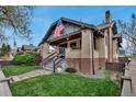 Charming brick home featuring a cozy front porch and well-maintained lawn at 1399 Newton St, Denver, CO 80204