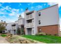 Exterior view of a two-story apartment building featuring brick accents and individual balconies at 7665 E Eastman Ave # 302B, Denver, CO 80231