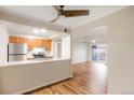 Open-concept kitchen with stainless steel appliances, breakfast bar, and wood floors at 7665 E Eastman Ave # 302B, Denver, CO 80231