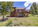 Rear exterior view of a two-story home featuring a large deck and stairs leading to the backyard at 173 Silver Cloud Ln, Boulder, CO 80302