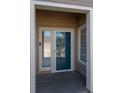 Entrance to a condo with a blue door, adjacent window, and visible unit number at 8435 Pebble Creek Way # 104, Highlands Ranch, CO 80126