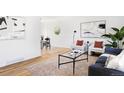 Open-concept living room with hardwood floors, a modern rug, and stylish contemporary decor at 8651 Franklin St, Denver, CO 80229