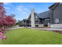 Expansive backyard features lush lawn, trees, and a multi-level deck on the modern home at 5859 E Ida Pl, Greenwood Village, CO 80111