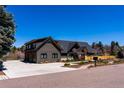 Modern home boasts sleek lines and a spacious driveway, surrounded by manicured landscaping at 5859 E Ida Pl, Greenwood Village, CO 80111