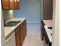 Well-lit kitchen featuring wood cabinets, stainless steel appliances, and tile flooring at 100 E Highline Cir # 105, Centennial, CO 80122