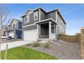 Two-story home with gray siding, white garage door, and landscaped lawn at 847 Ledge St, Lochbuie, CO 80603