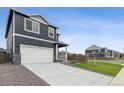 Two-story home with gray siding, white garage door, and landscaped lawn at 847 Ledge St, Lochbuie, CO 80603