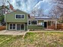 The backyard features a well-kept lawn, sliding glass doors, patio, and solar panels on the roof at 6640 S Heritage W Pl, Centennial, CO 80111