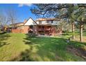 Expansive backyard with a well-maintained lawn, mature trees, a patio, and a deck for outdoor living at 8409 Lightening View Dr, Parker, CO 80134