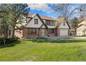 Two-story home with brick and vinyl siding, attached garage, and a lush green lawn at 8409 Lightening View Dr, Parker, CO 80134