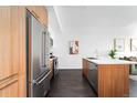 A modern kitchen featuring stainless steel appliances and a convenient island, with dark wood flooring at 2880 Zuni St # 309, Denver, CO 80211