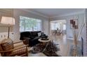 Bright living room featuring hardwood floors, a cozy sofa, and large windows at 2812 Krameria St, Denver, CO 80207
