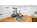 Bright living room featuring hardwood floors, modern furniture, and a cozy rug at 7841 Oneida St, Commerce City, CO 80022
