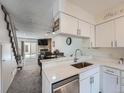 White kitchen with stainless steel appliances and quartz countertops at 14222 E Hawaii Cir # F, Aurora, CO 80012