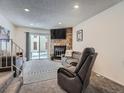Comfortable living room featuring a stone fireplace, a sliding glass door and neutral color palette at 14222 E Hawaii Cir # F, Aurora, CO 80012