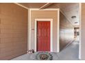 Apartment entryway featuring a red door, welcome mat, and neutral siding at 7440 S Blackhawk St # 4-105, Englewood, CO 80112