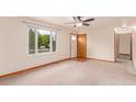 Bright living room featuring neutral carpeting, a large window, and a ceiling fan at 3780 E 117Th Ave, Thornton, CO 80233