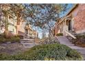 Townhouses with brown siding and brick chimneys are accessed by short flights of stairs and landscaping at 2062 S Helena St # B, Aurora, CO 80013