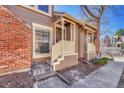 Close up exterior view of a townhouse's front porch with brown siding and cream painted railings at 2062 S Helena St # B, Aurora, CO 80013