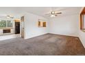 Spacious living room with plush carpet and a view into the kitchen at 6609 W Mexico Pl, Lakewood, CO 80232