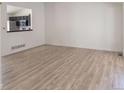 Bright living room with wood floors and a view of the modern kitchen at 14608 E 52Nd Ave, Denver, CO 80239