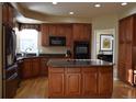 Bright kitchen boasts wood floors, granite counters, stainless appliances, central island and plenty of cabinets at 6368 S Walden Way, Aurora, CO 80016