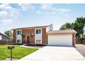 Inviting two-story brick home featuring a well-kept lawn, two-car garage, and a charming front entrance at 10932 W 107Th Ave, Broomfield, CO 80021