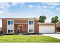 Beautiful two-story brick home with an attached two-car garage and manicured front lawn at 10932 W 107Th Ave, Broomfield, CO 80021