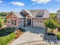 Charming home featuring stone accents, a manicured lawn, and a two-car garage at 6999 S Tempe Ct, Aurora, CO 80016