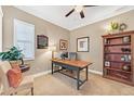 Bright home office space featuring a wooden desk, chair, and custom built-in shelving at 6999 S Tempe Ct, Aurora, CO 80016