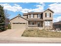 Charming two-story home features a welcoming front porch, attached garage, and a well-maintained lawn at 7099 Cerney Cir, Castle Pines, CO 80108