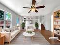 Bright living room with white walls, hardwood floors, ceiling fan, and abundant natural light at 5005 W 128Th Pl, Broomfield, CO 80020