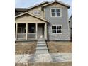 Charming two-story home with a covered porch and neutral-colored siding at 15267 Fillmore St, Thornton, CO 80602