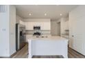 Bright kitchen with stainless steel appliances, an island and white cabinetry at 15267 Fillmore St, Thornton, CO 80602