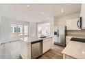 Modern kitchen features stainless appliances, quartz counters and an island with a sink at 15267 Fillmore St, Thornton, CO 80602
