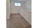 Clean loft space featuring neutral carpeting, white walls, a railing, and natural light at 15267 Fillmore St, Thornton, CO 80602