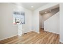 Bright room with wood-look flooring, white walls and large windows near the staircase at 1417 Bloom St, Brighton, CO 80601