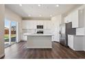 Modern kitchen with white cabinetry, stainless steel appliances, and a central island at 1417 Bloom St, Brighton, CO 80601