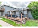 Back of the gray house featuring a wooden patio and metal fence at 7925 York St # 2, Denver, CO 80229