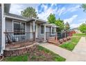 Charming gray home featuring a welcoming front porch with a black metal fence at 7925 York St # 2, Denver, CO 80229