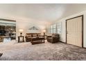 Cozy living room with neutral carpet, plantation shutters and comfortable seating arrangement at 678 S Oswego Ct, Aurora, CO 80012
