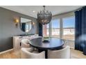 Elegant dining room with modern chandelier, stylish buffet, and large windows framing a picturesque landscape at 8576 Hotchkiss St, Littleton, CO 80125