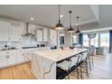 Bright kitchen featuring a large island with seating, modern appliances, and an adjacent dining area with scenic views at 8576 Hotchkiss St, Littleton, CO 80125