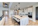 Spacious kitchen boasts a sizable island with seating, stainless steel appliances, and a seamless connection to the living space at 8576 Hotchkiss St, Littleton, CO 80125