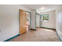 Bright bedroom with a closet featuring a sliding door and a window overlooking the yard at 310 Jay St, Lakewood, CO 80226