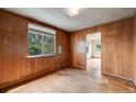 Cozy bedroom featuring wood paneled walls, a large window and hardwood floors at 310 Jay St, Lakewood, CO 80226