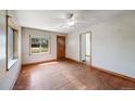 Bright living room with hardwood floors, a ceiling fan, and large windows at 310 Jay St, Lakewood, CO 80226