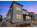 Modern two-story home showcasing a sleek design with large windows and neat landscaping at dusk at 19197 E 64Th Ave, Denver, CO 80249