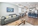 Open-concept living area with hardwood floors and a modern kitchen featuring an island and stainless steel appliances at 19197 E 64Th Ave, Denver, CO 80249
