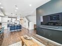 Open-concept living space with hardwood floors and a modern kitchen island; stairs leading to the second floor at 19197 E 64Th Ave, Denver, CO 80249